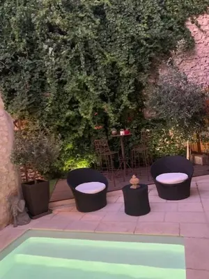 a group of chairs and a pool in a garden at Un havre de paix au coeur de la Provence in Châteaurenard