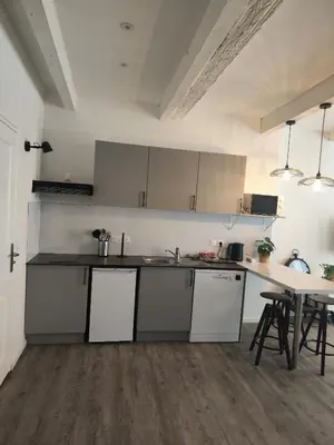 a kitchen with white cabinets and a table at Bon Pasteur in Aix-en-Provence