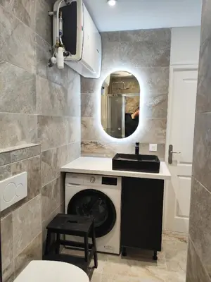a bathroom with a washing machine and a sink at Bon Pasteur in Aix-en-Provence