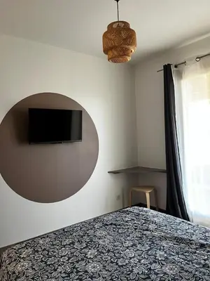 a bedroom with a bed and a flat screen tv on the wall at Chambre d hôtes chez l habitant in Velaux