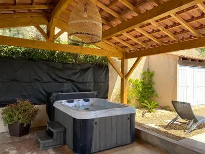 a hot tub sitting under a wooden pergola at Chambre d hôtes chez l habitant in Velaux