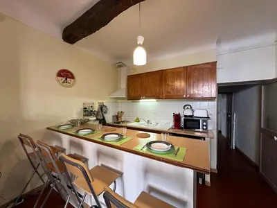 a kitchen with a counter with chairs and a microwave at Chez Florence - Appartement T2 d au cœur du centre ville historique - Proche Cardeurs et Mairie in Aix-en-Provence