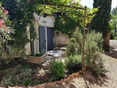 a garden with a table and chairs in front of a building at Les Gites de Catherine in Gargas