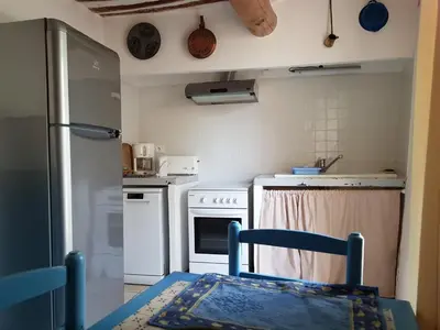 a kitchen with white appliances and a blue chair in it at Les Gites de Catherine in Gargas