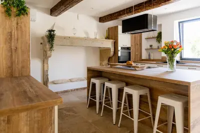 a kitchen with a wooden counter and stools at Mas mes Aïeux in Saint-Rémy-de-Provence
