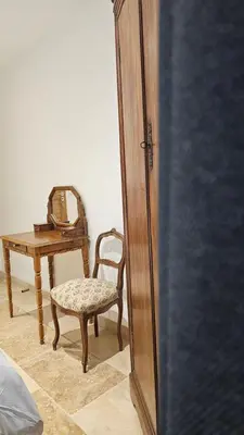 a room with a chair and a table with a mirror at Mas mes Aïeux in Saint-Rémy-de-Provence