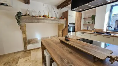 a kitchen with a wooden table in the middle at Mas mes Aïeux in Saint-Rémy-de-Provence
