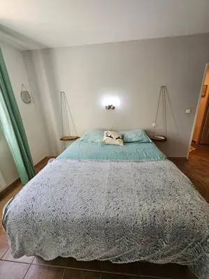a bedroom with a large bed with a blue comforter at Maison des Fenaisons in Entraigues-sur-la-Sorgue