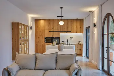 a living room with a couch and a kitchen at TERRE UGO - Villa & Suites au cœur des lavandes de Provence in Aix-en-Provence