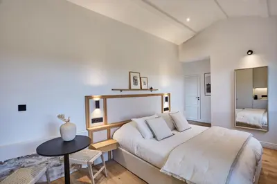 a bedroom with a large bed and a mirror at TERRE UGO - Villa & Suites au cœur des lavandes de Provence in Aix-en-Provence