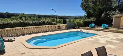 a swimming pool in a patio with chairs at Restanques de la Tour in La Tour-dʼAigues