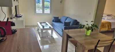 a living room with a blue couch and a table at Restanques de la Tour in La Tour-dʼAigues