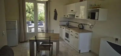 a kitchen with white cabinets and a table with a dining room at Restanques de la Tour in La Tour-dʼAigues