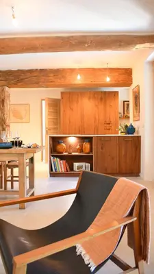 a kitchen with wooden cabinets and a bench in a room at La Piscine dans la Foret in Gordes