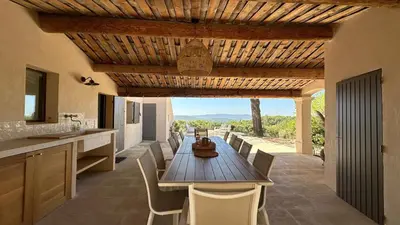 a dining room with a wooden table and chairs at La canopée, Bastide sur les hauteurs de Lourmarin in Lourmarin