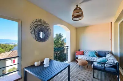 a living room with a couch and a table on a balcony at appartement pont royal in Mallemort