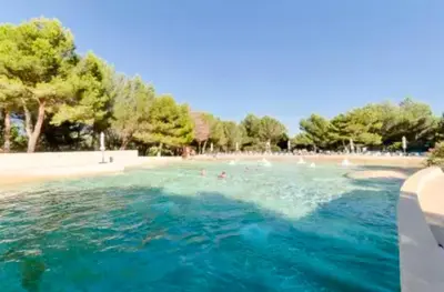 a swimming pool with people in the water at appartement pont royal in Mallemort