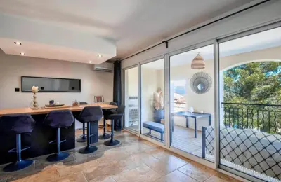 a bedroom with a balcony with a desk and chairs at appartement pont royal in Mallemort
