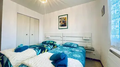 two beds in a room with blue and white sheets at Rendez-vous en Provence -10 personnes- duo de gîtes- piscine privée - clim in Cheval-Blanc