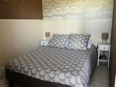 a bedroom with a bed and two nightstands and two lamps at Domaine Les feuilles de Chêne in Carpentras