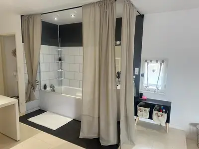 a bathroom with a tub and a shower curtain at Le mazet in Pélissanne