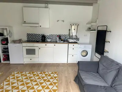 a living room with a couch and a kitchen at Le mazet in Pélissanne