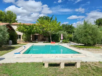 a swimming pool with a bench in front of a house at La bastide le Jucamas in Saint-Saturnin-les-Apt
