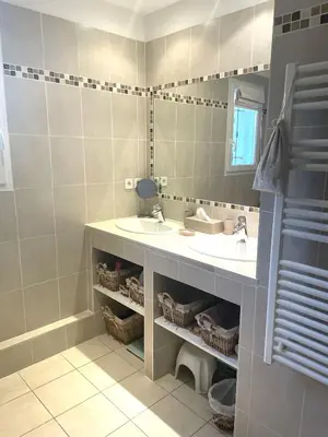 a bathroom with two sinks and a mirror at La bastide le Jucamas in Saint-Saturnin-les-Apt