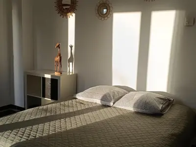 a bedroom with a bed with a table and a mirror at Studio privé confortable avec terrasse, parking et Wi-Fi in Aix-en-Provence