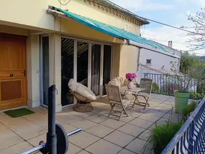 a patio with a table and chairs on a house at Studio privé confortable avec terrasse, parking et Wi-Fi in Aix-en-Provence