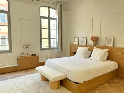 a bedroom with a large bed with a wooden frame at Le Pénélope in Aix-en-Provence
