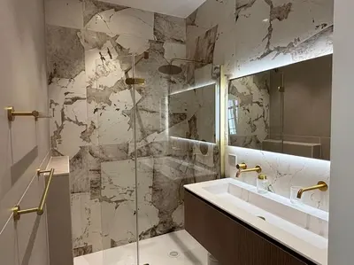 a bathroom with a sink and a marble wall at Le Pénélope in Aix-en-Provence