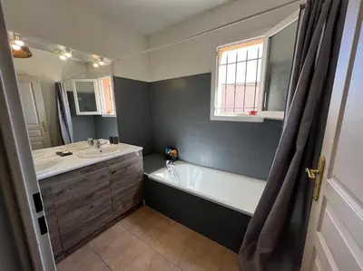 a bathroom with a bath tub and a sink at La Villa Nawengo in Le Thor
