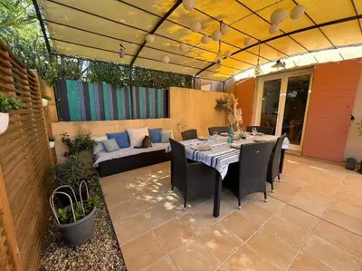 a patio with a table and chairs and a couch at La Villa Nawengo in Le Thor