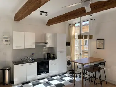 a kitchen with white cabinets and a table with chairs at Le Prêcheur in Aix-en-Provence