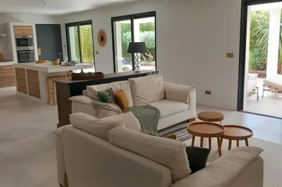 a living room with two couches and a kitchen at Appartement Indépendant avec Jardin et Piscine en Provence in Ventabren
