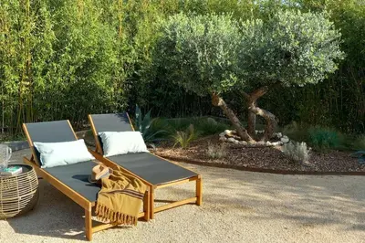 two chairs and a table with a tree in the background at Appartement Indépendant avec Jardin et Piscine en Provence in Ventabren