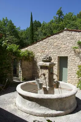 a white bedroom with a bed and a chair at Mas du Loriot in Murs
