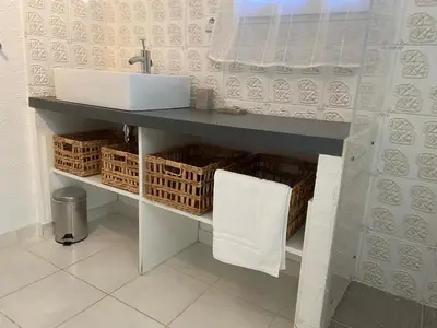 a bathroom with a sink and baskets under it at Studio Estrella - Studio 2 personnes - Domaine Astra, Grans in Grans