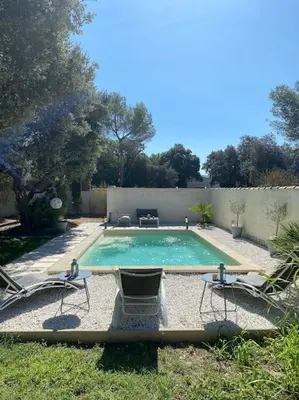 a swimming pool with two chairs and a table at Maison de Vacances en Provence in Venasque