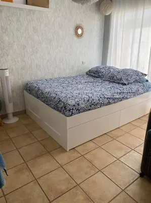 a bed sitting in a bedroom with a window at Maison de Vacances en Provence in Venasque