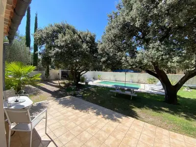 a backyard with a swimming pool and a tree at Maison de Vacances en Provence in Venasque