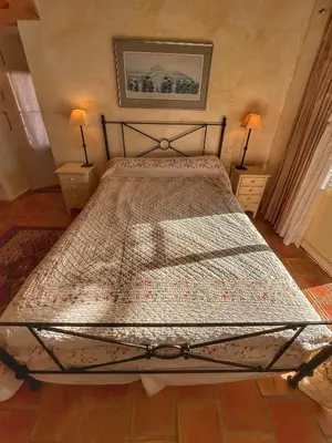 a bed in a bedroom with two lamps on tables at Les 3 Terrasses in Roussillon
