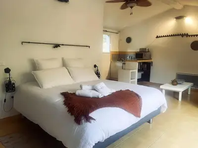 a bedroom with a large white bed with a brown blanket at Studio Soléa - Studio 2 - 4 personnes - Domaine Astra, Grans in Grans