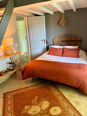 a bedroom with a large bed with red pillows at Chambre dans bastide au milieu des vignes in Ménerbes