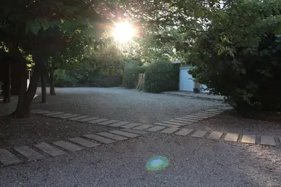 a garden with a sun shining through some trees at La Maison Alma - de 4 à 12 personnes - Domaine Astra, Grans in Grans