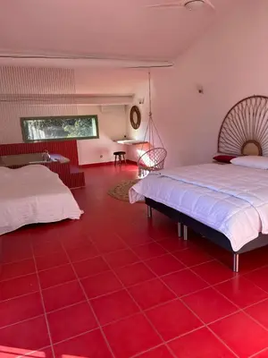 a room with two beds and a red tiled floor at La Maison Alma - de 4 à 12 personnes - Domaine Astra, Grans in Grans