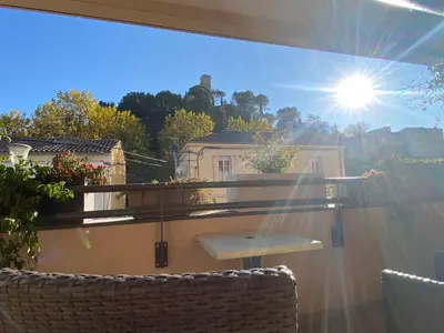 a window with a view of a balcony with the sun at T3 au pied des Tours du Château in Châteaurenard