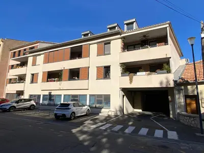 a white building with cars parked in front of it at T3 au pied des Tours du Château in Châteaurenard