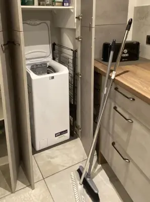a mop in a kitchen with a trash can at T3 au pied des Tours du Château in Châteaurenard